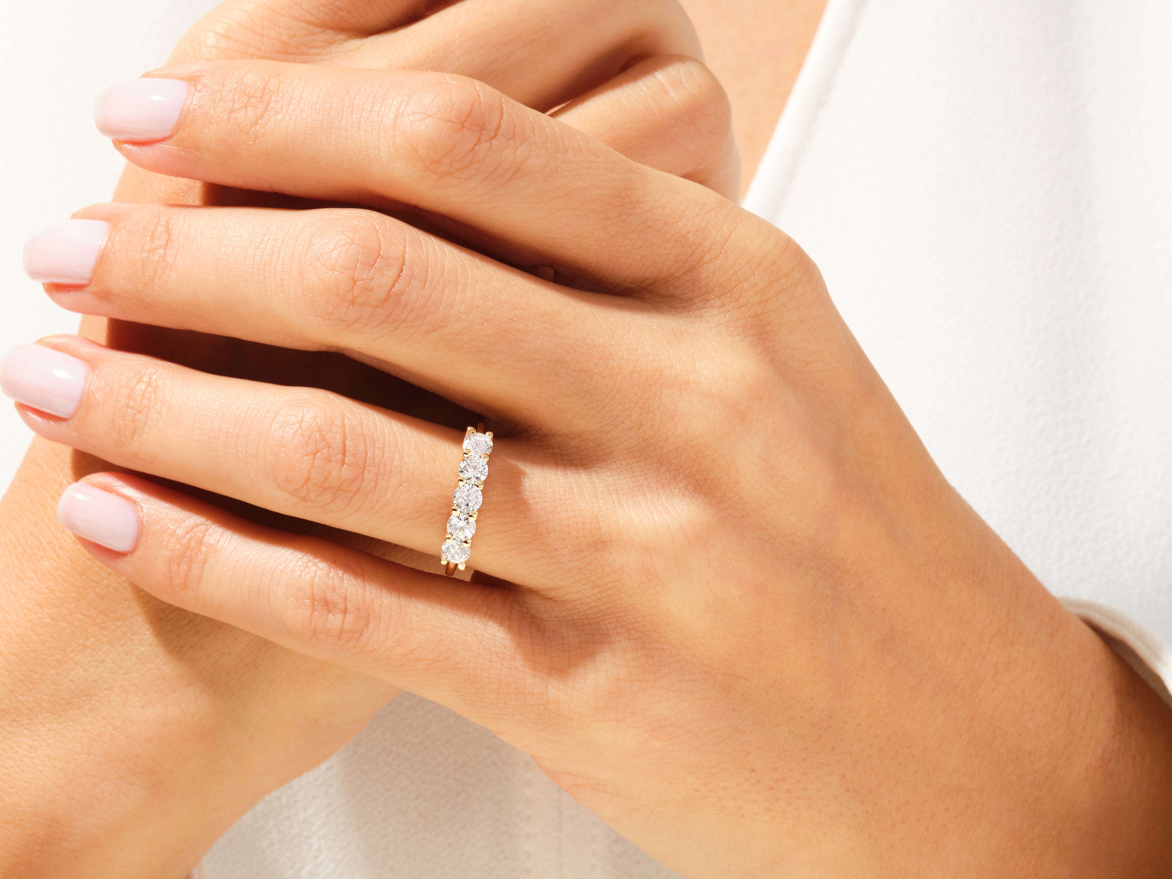 Gold diamond band ring on a woman's finger, jewelry