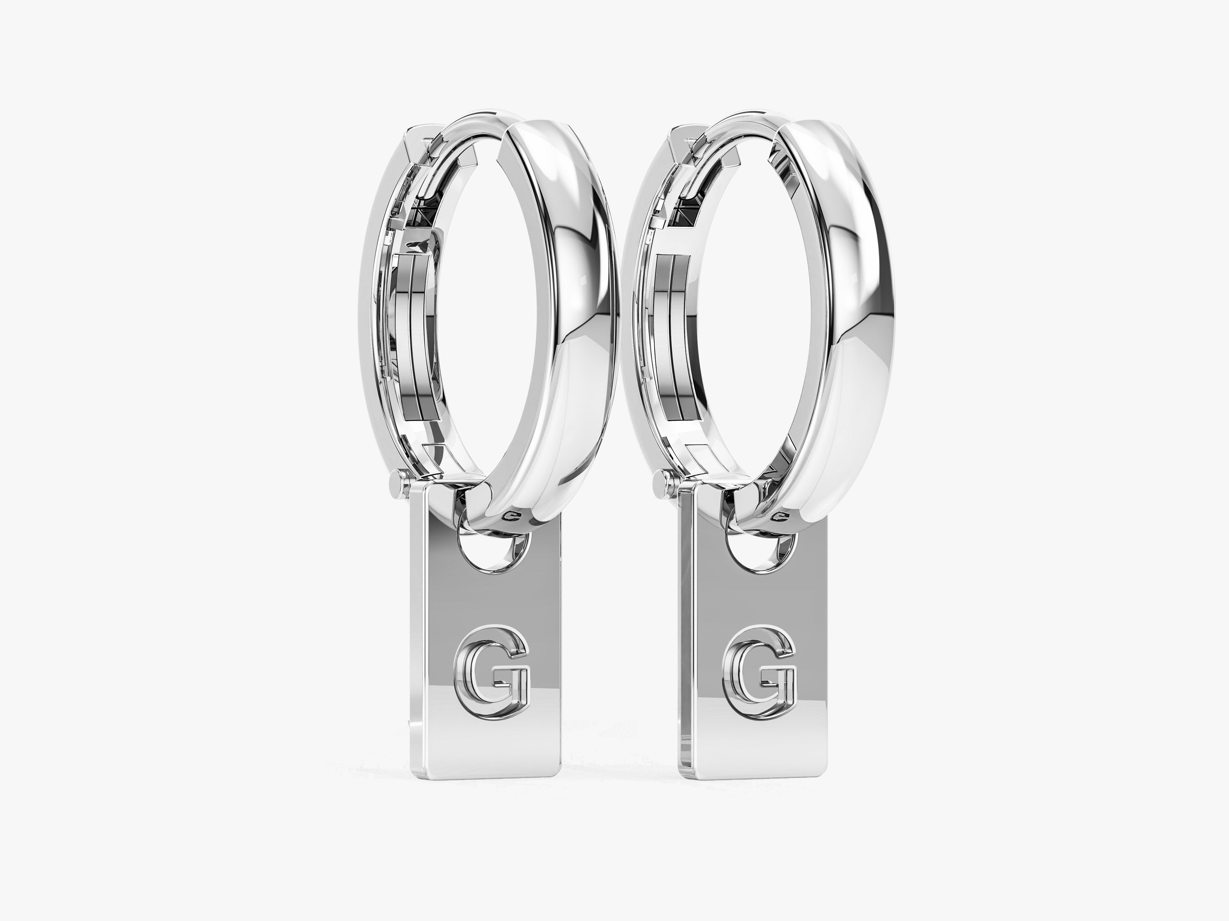 Silver hoop earrings with dangling 'G' initial charms