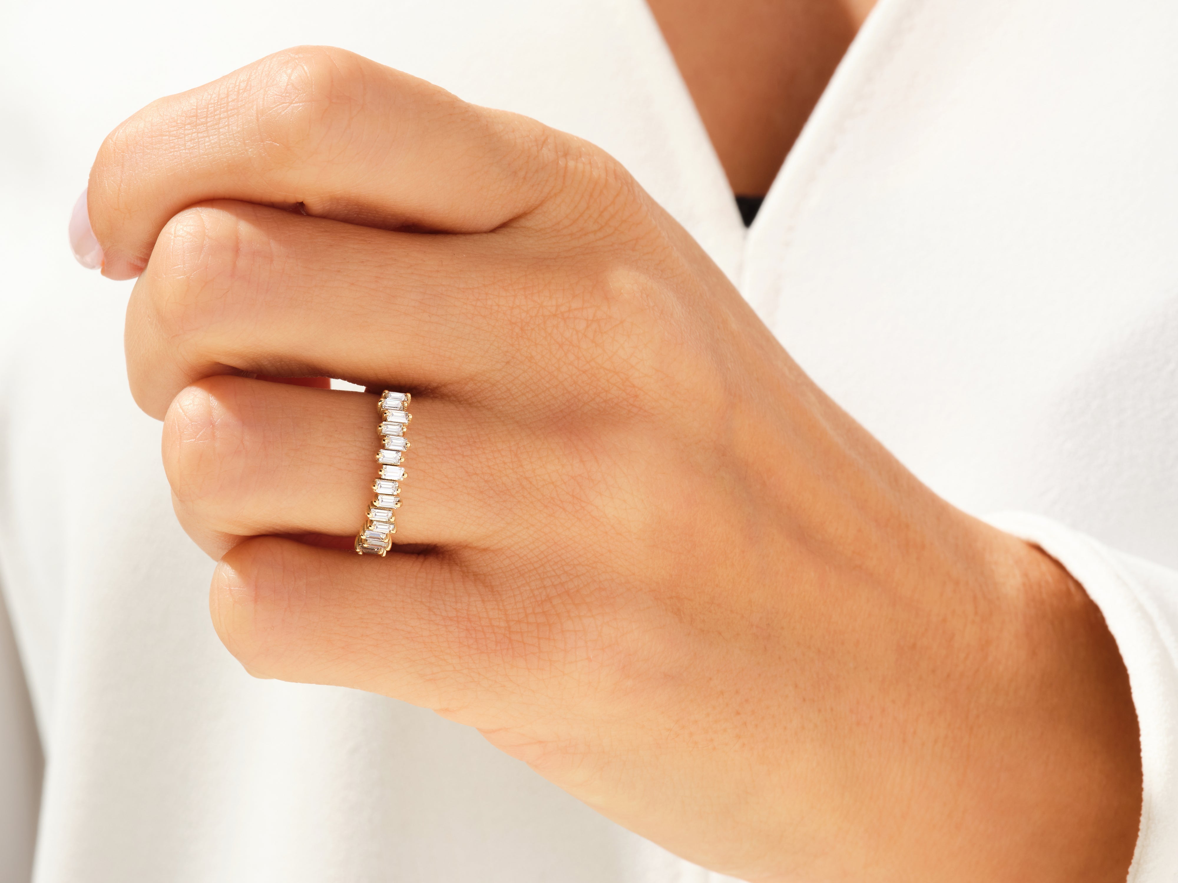 Baguette diamond eternity ring on a hand, fine jewelry