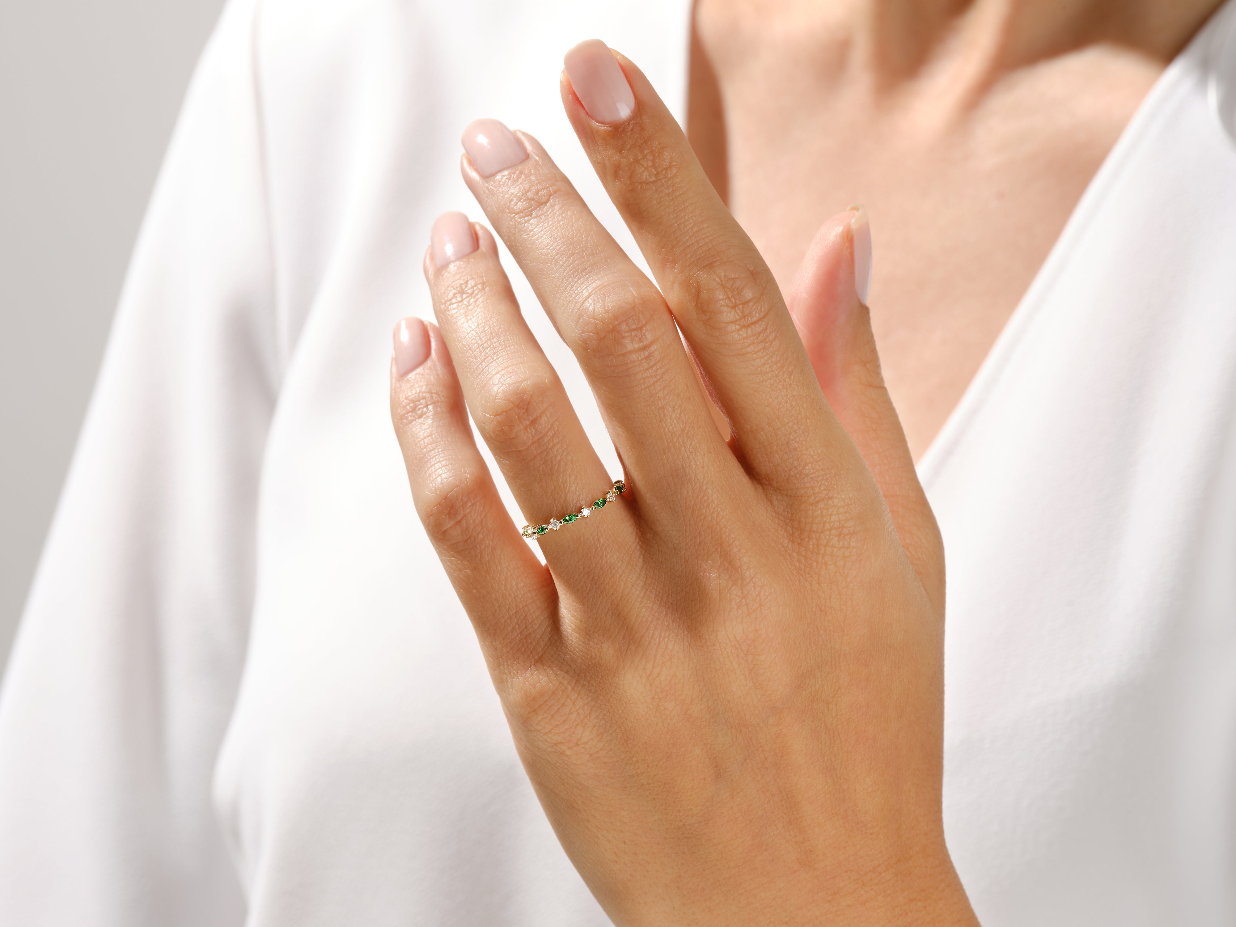 Delicate emerald and diamond ring on a woman's hand