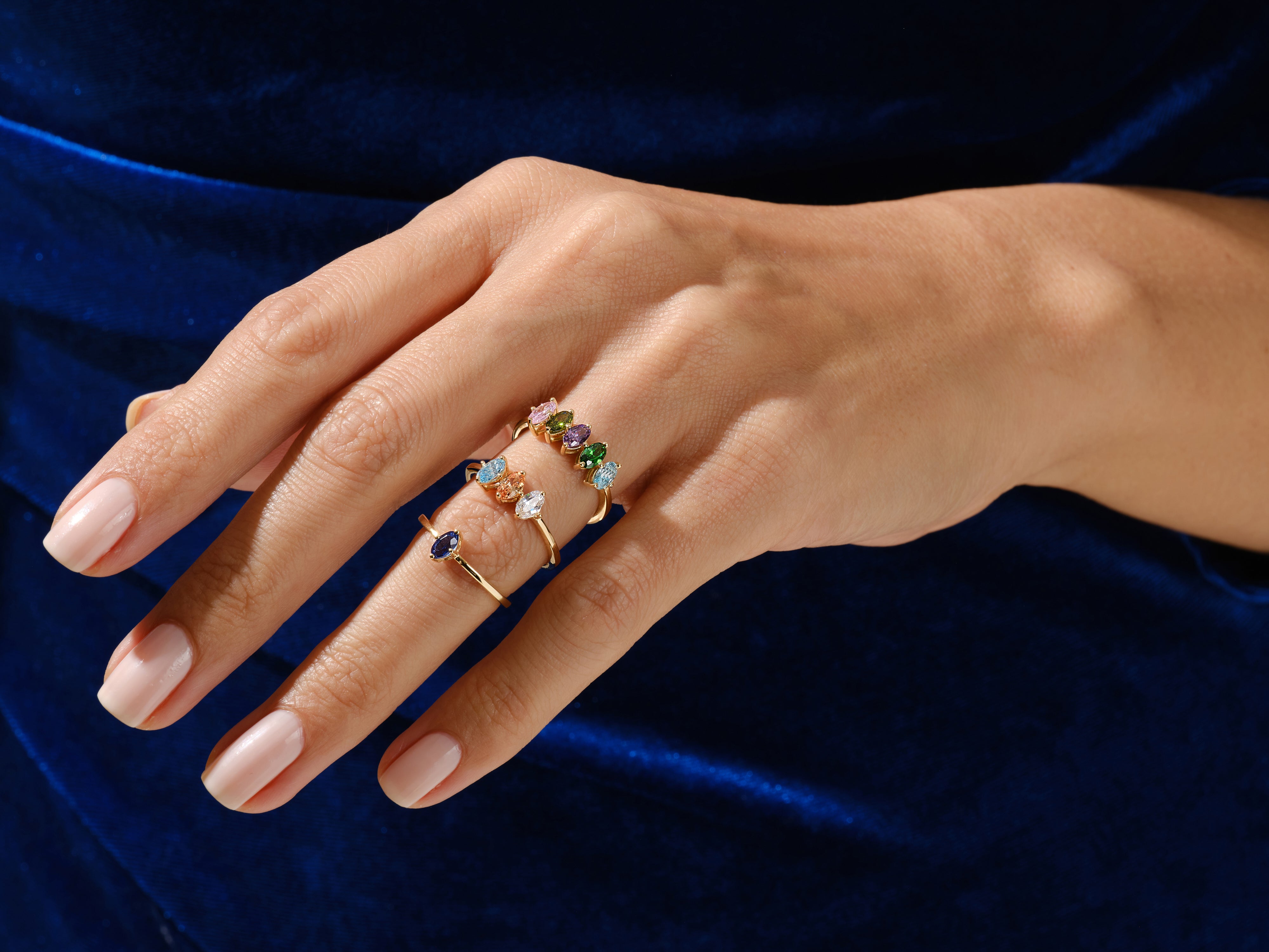 Gold rings with colorful gemstones on a hand