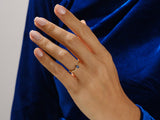 Gold ring with pear-shaped sapphire on hand