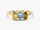 Gold ring with three pear-shaped gemstones: yellow, blue, and yellow