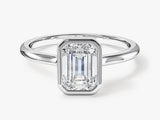 Emerald cut diamond engagement ring in a bezel setting