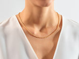 Gold diamond bezel set necklace on a woman's neck