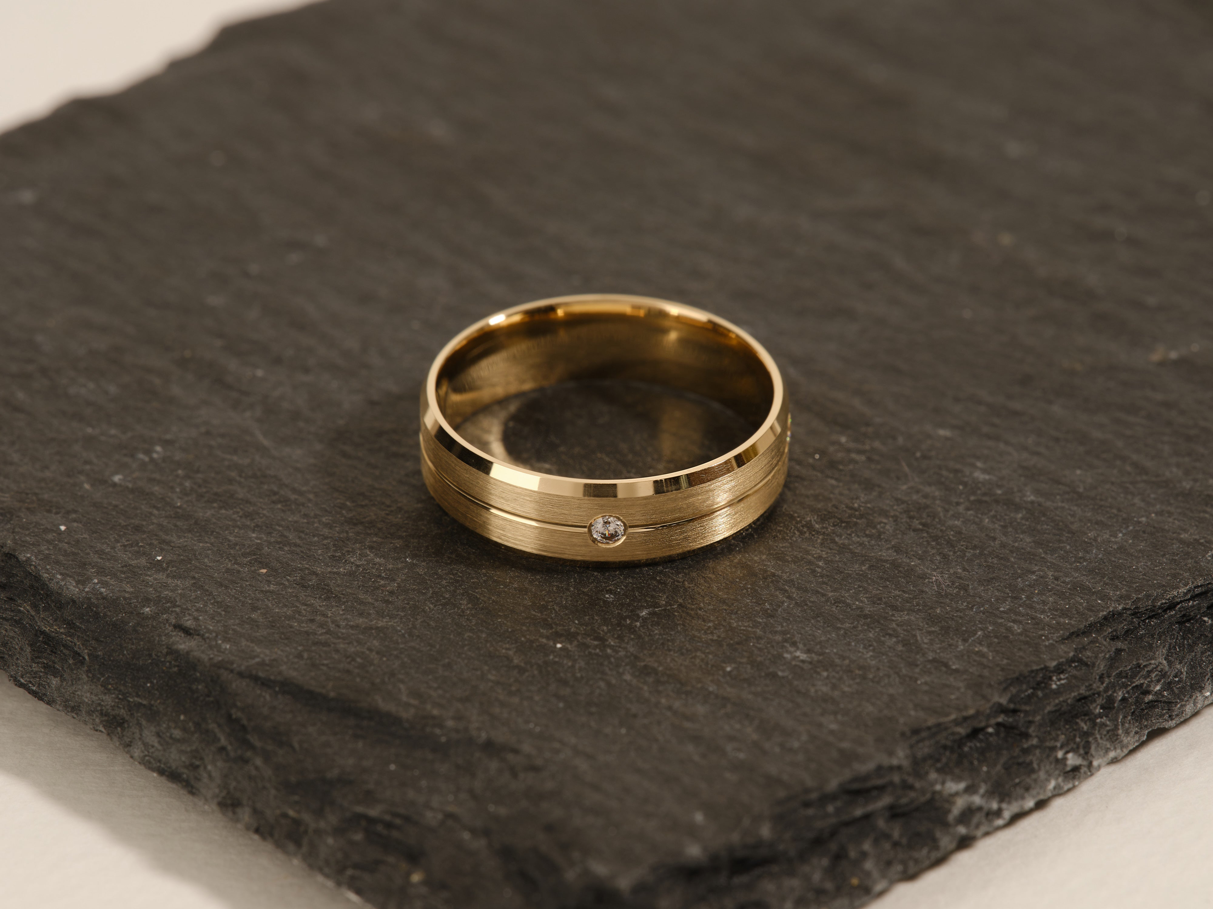 Gold wedding band with diamond accent on slate