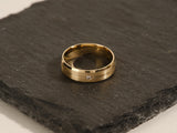 Gold wedding band with diamond accent on slate