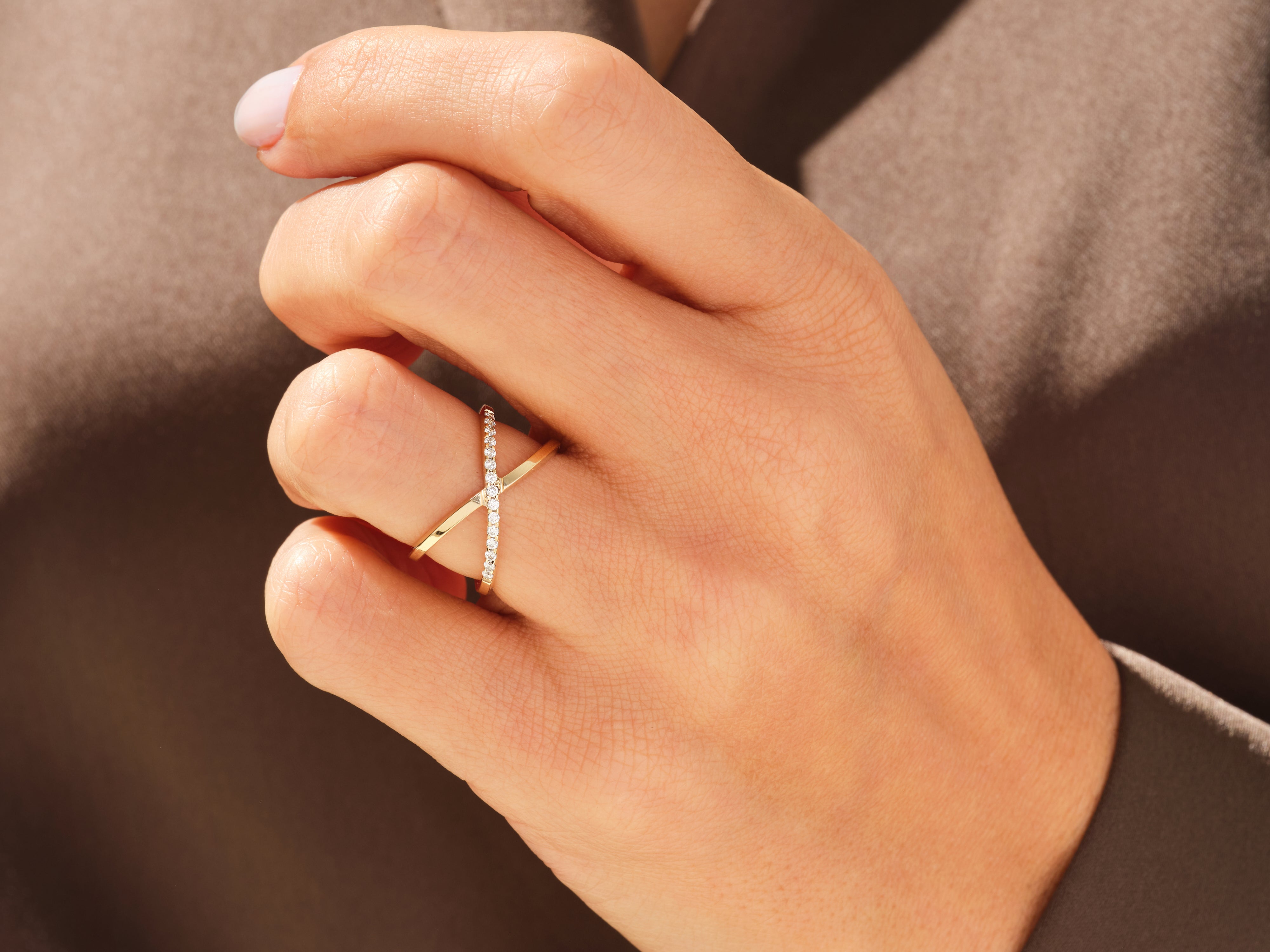 Diamond criss-cross ring on a hand, fine jewelry for women