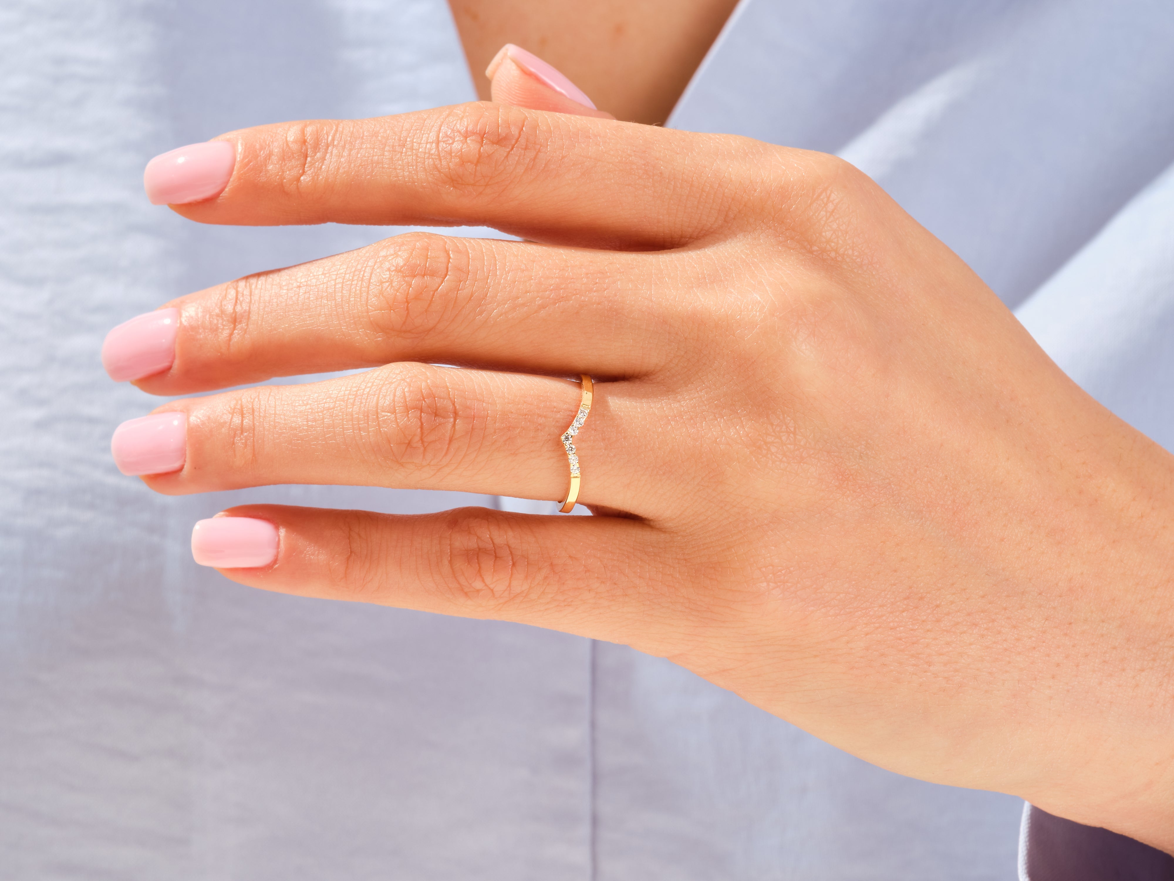 Diamond curved band ring on a woman's finger