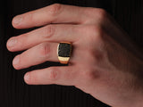 Gold ring with black diamonds on a man's finger