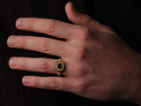 Gold ring with black stone on hand