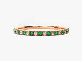 Rose gold eternity band with emerald and diamond gemstones