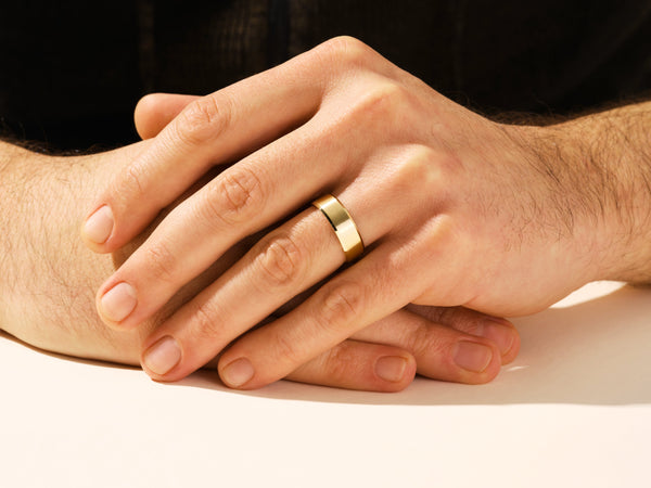 Gold wedding band on man's hand, jewelry for him
