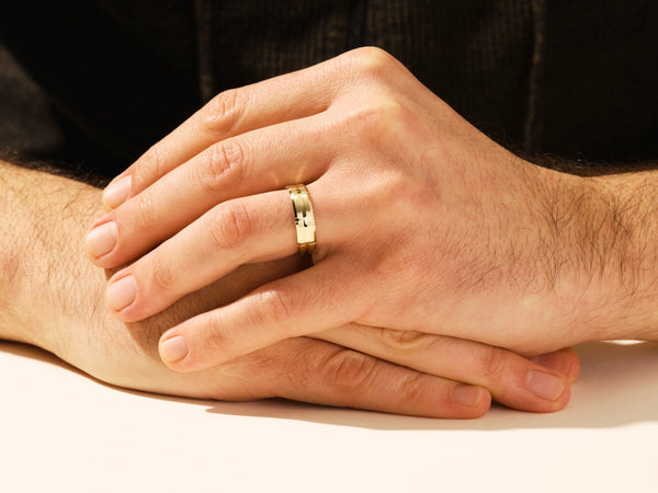 Gold wedding band on man's hand, jewelry for men
