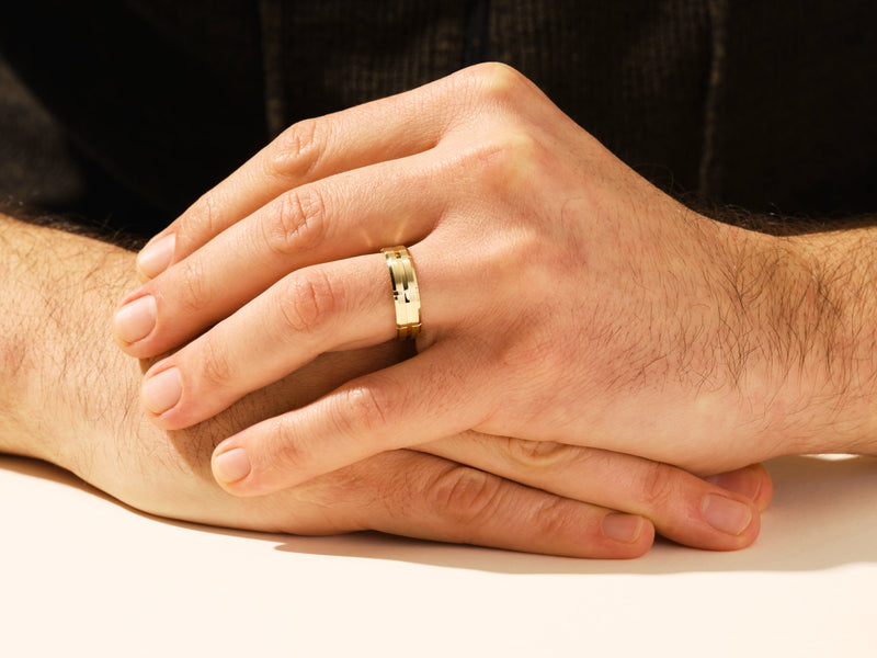 Gold wedding band on man's hand, jewelry for men