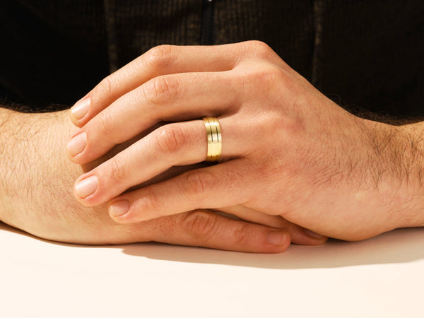 Gold wedding band on man's hand, jewelry for men