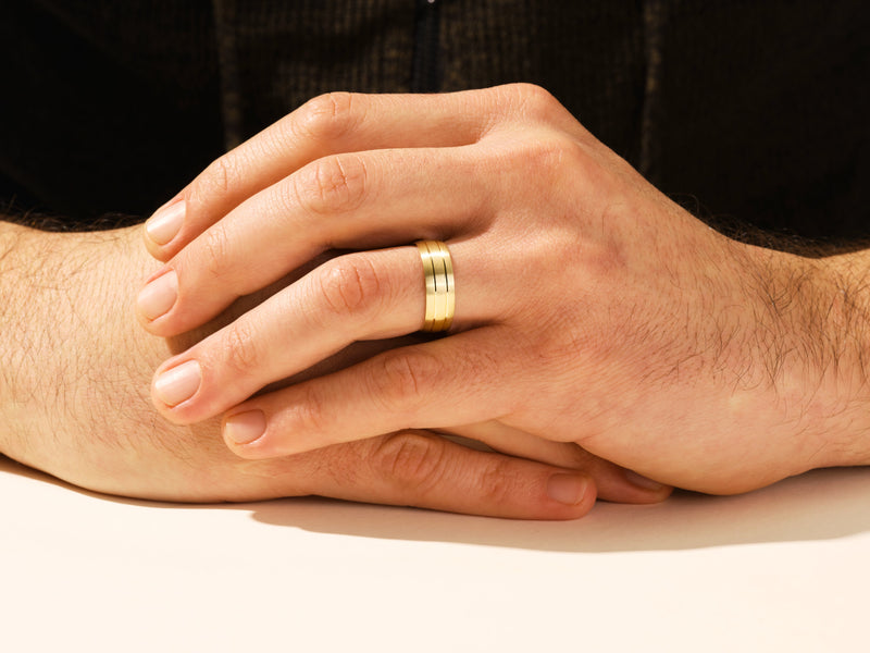 Gold wedding band on man's hand, jewelry for men