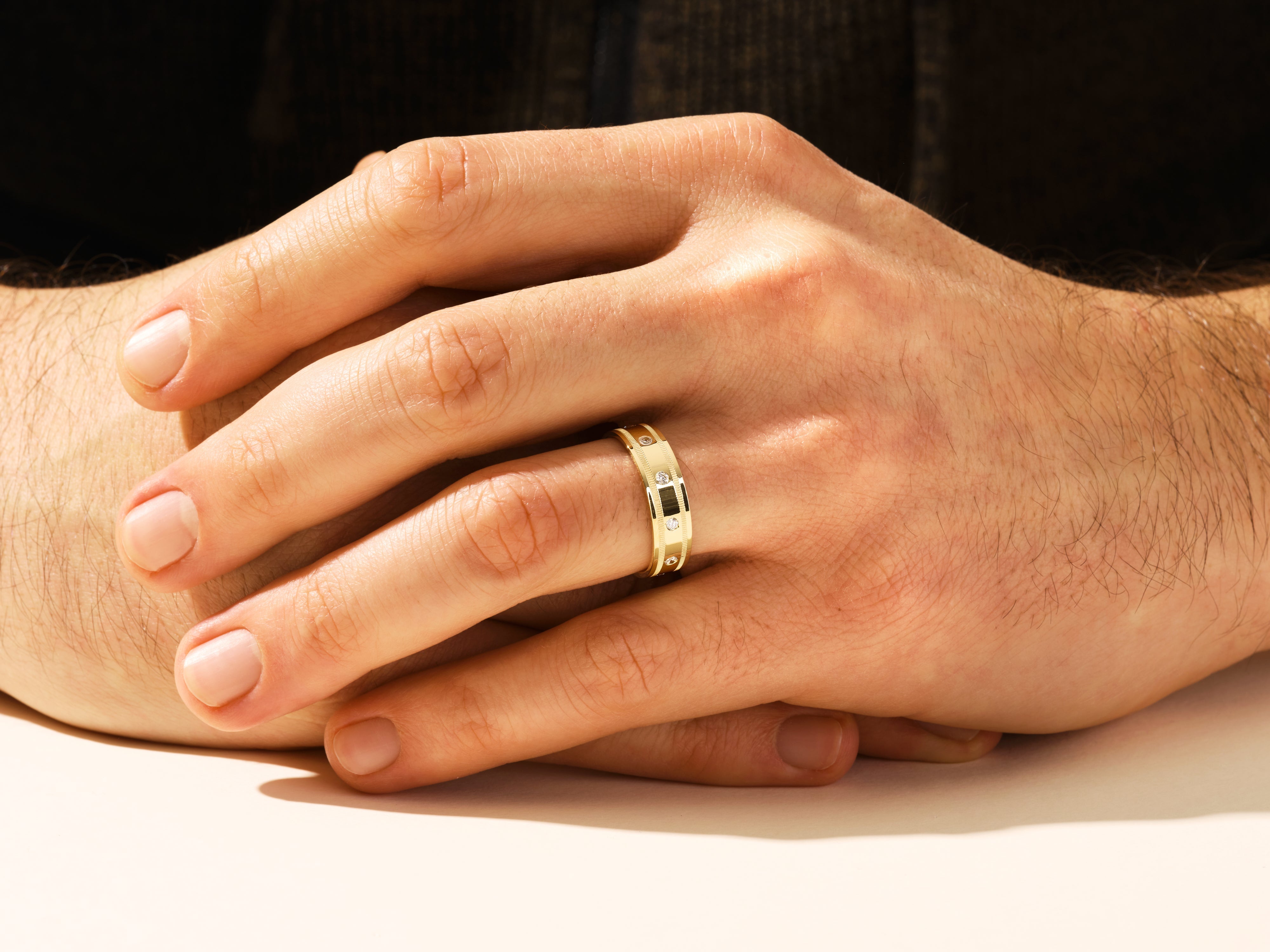 Gold ring with diamonds and black stone on man's hand