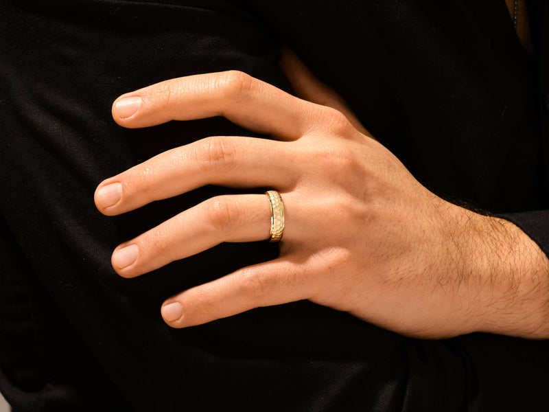 Gold hammered ring on a man's finger, jewelry photography