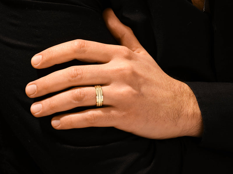 Gold wedding band on a man's hand, jewelry for sale
