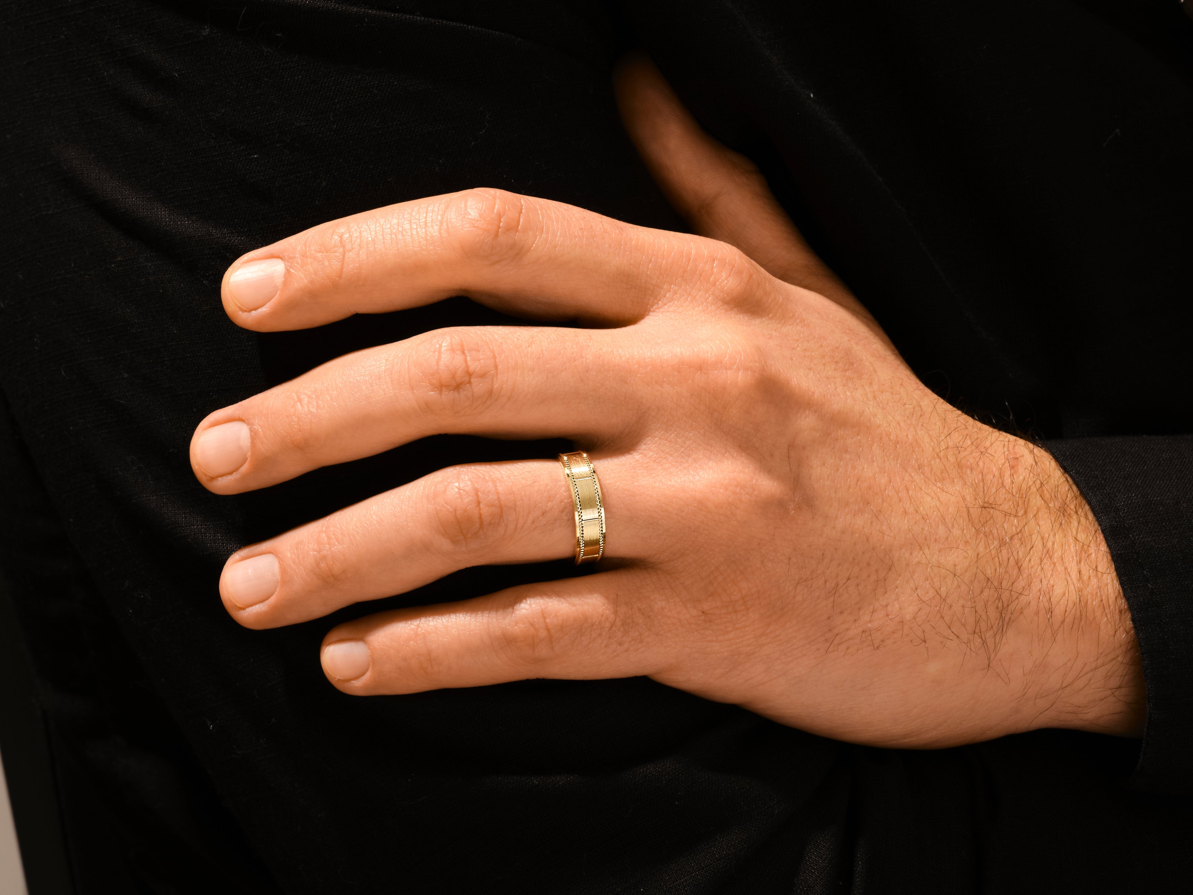Gold textured band ring on a man's finger