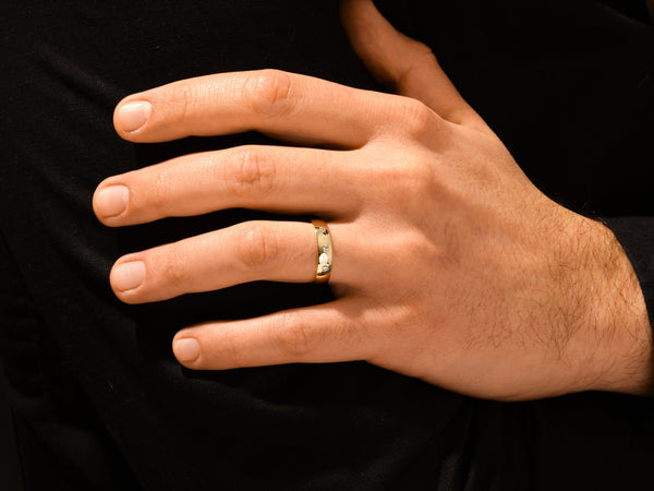 Gold ring with diamonds on a man's finger