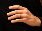 Gold band ring on a man's finger, luxury jewelry