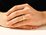 Gold wedding band on man's finger, jewelry firm product
