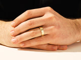Gold wedding band on man's finger, jewelry firm product
