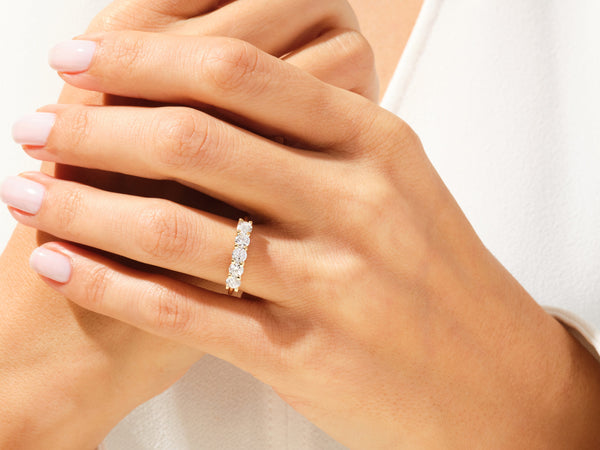 Gold diamond band ring on a woman's finger, jewelry