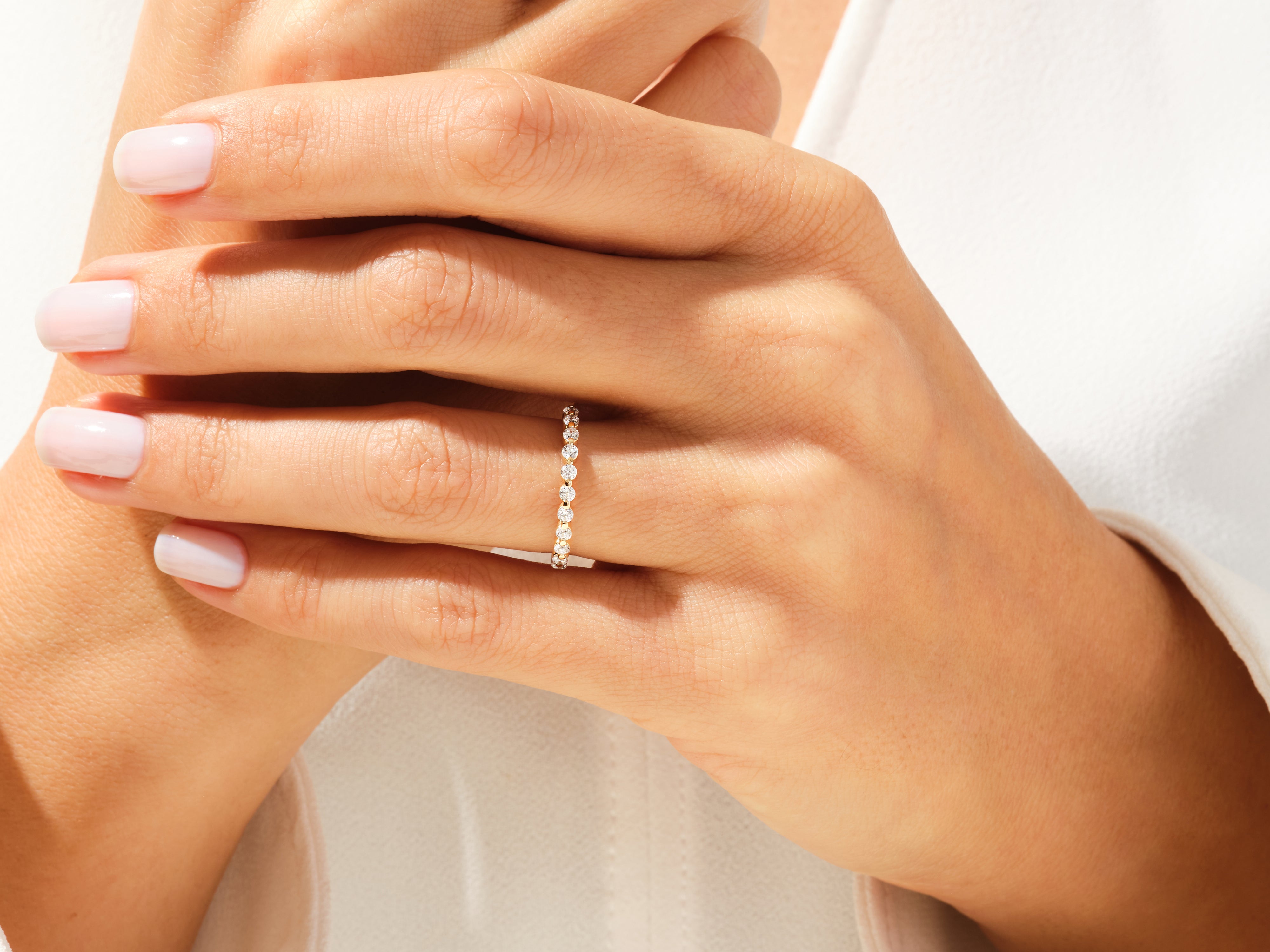 Diamond eternity band on a woman's finger, jewelry