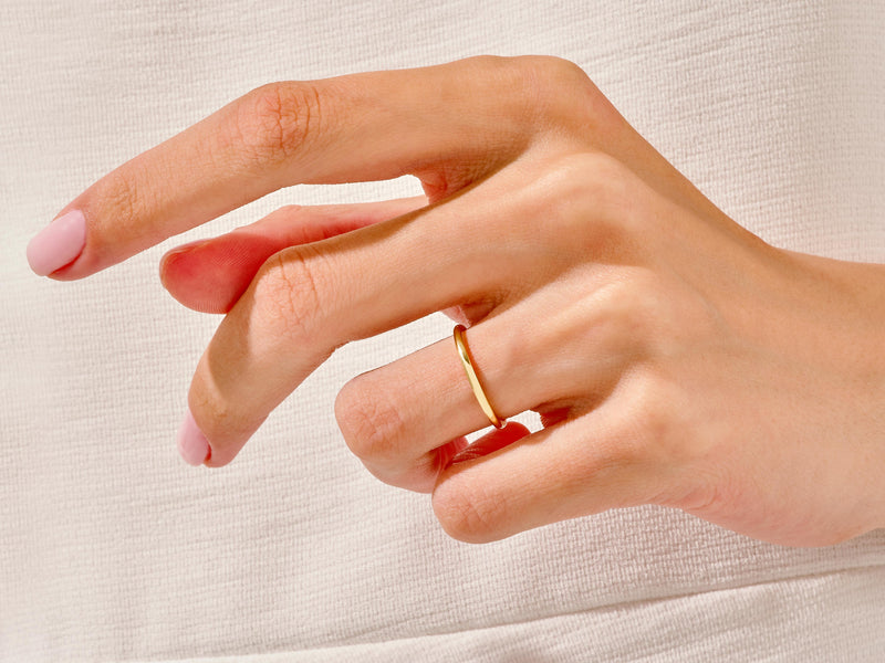 Minimalist gold ring on a hand, jewelry product photography