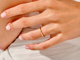 Minimalist gold band ring on a woman's finger, jewelry