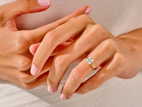 Gold ring with princess cut diamond on a woman's hand