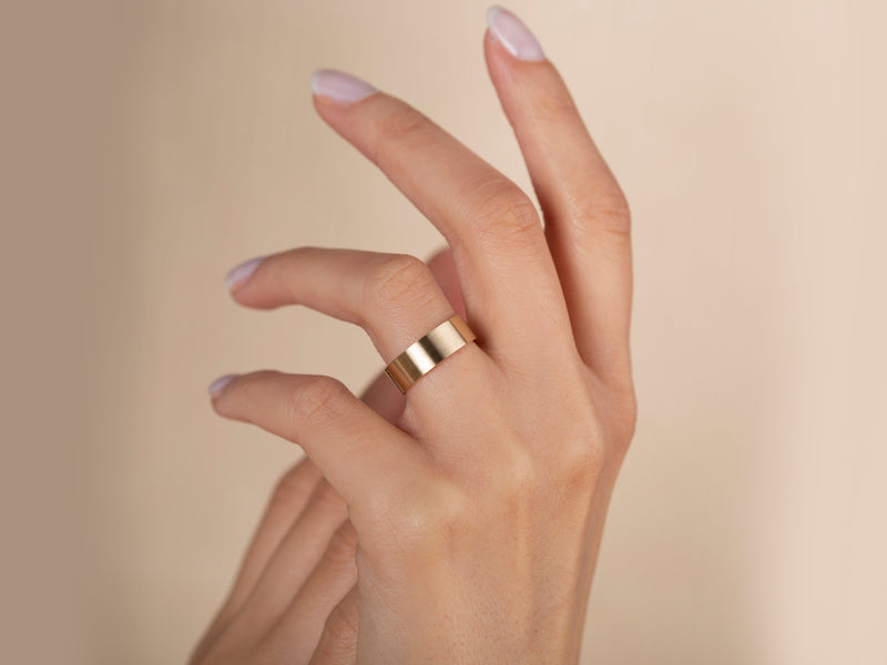 Gold band ring on a woman's finger, jewelry photography