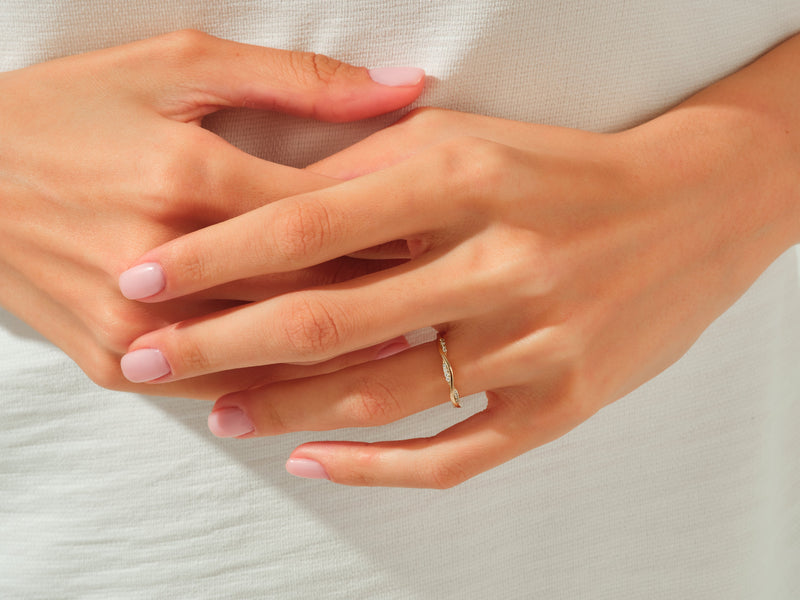 Diamond twisted band ring on a woman's finger, jewelry