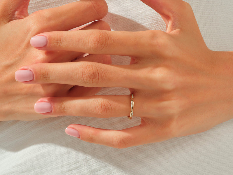 Diamond twisted band ring on a woman's finger