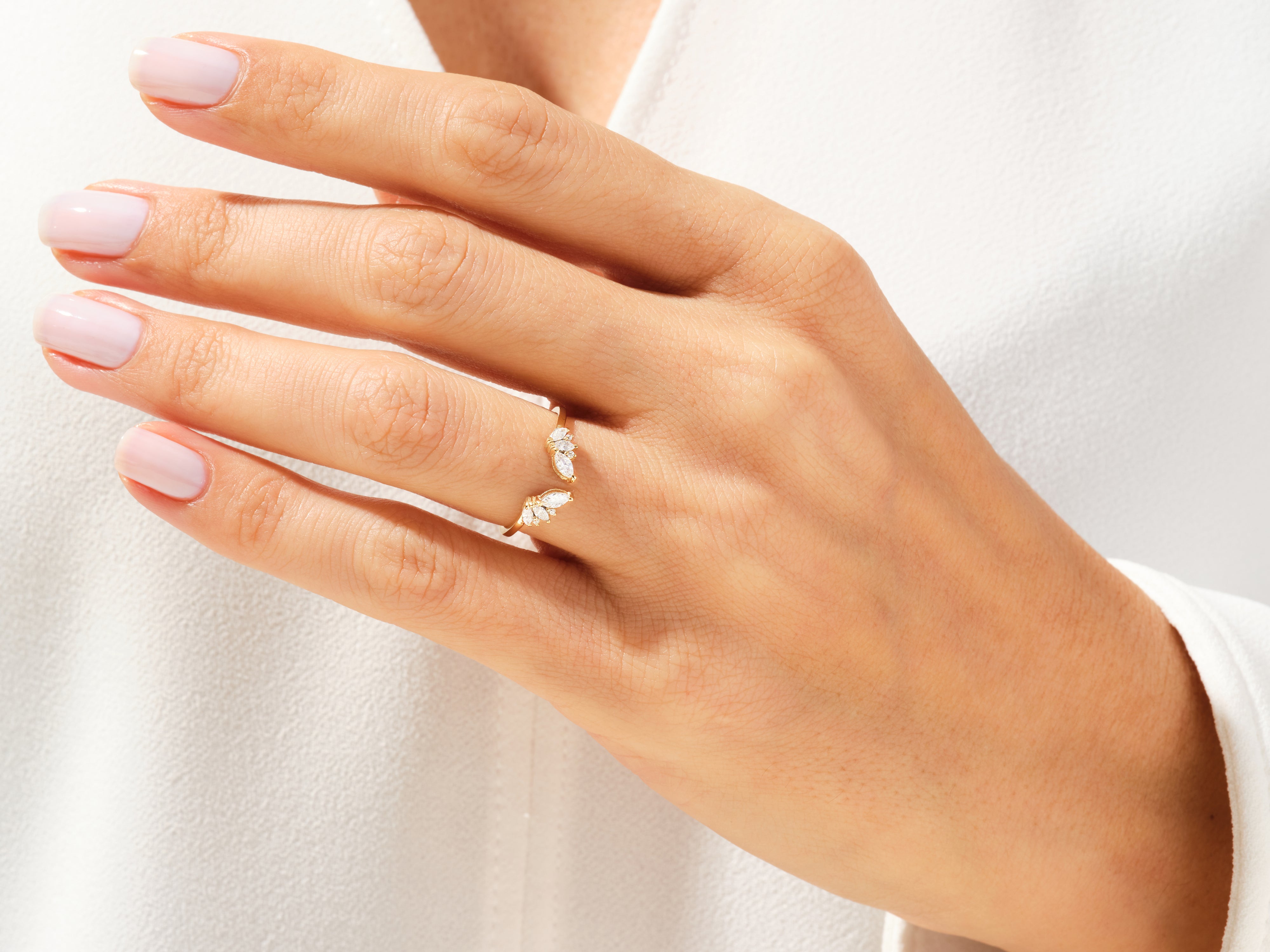 Gold diamond ring with marquise-cut stones on a woman's finger