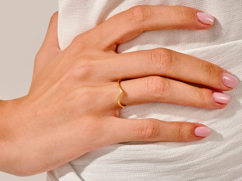 Gold V-shaped ring on a woman's finger, jewelry