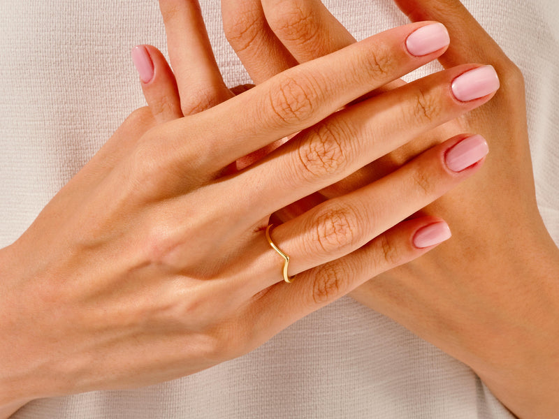 Gold chevron ring on hand with pink nails, jewelry