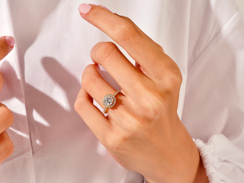 Diamond halo engagement ring on a hand