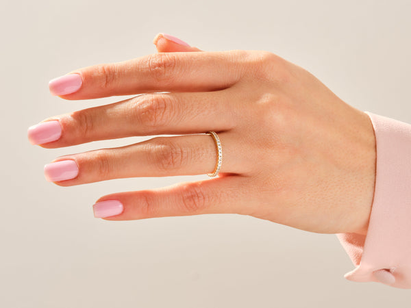 Delicate diamond eternity band on a hand, jewelry