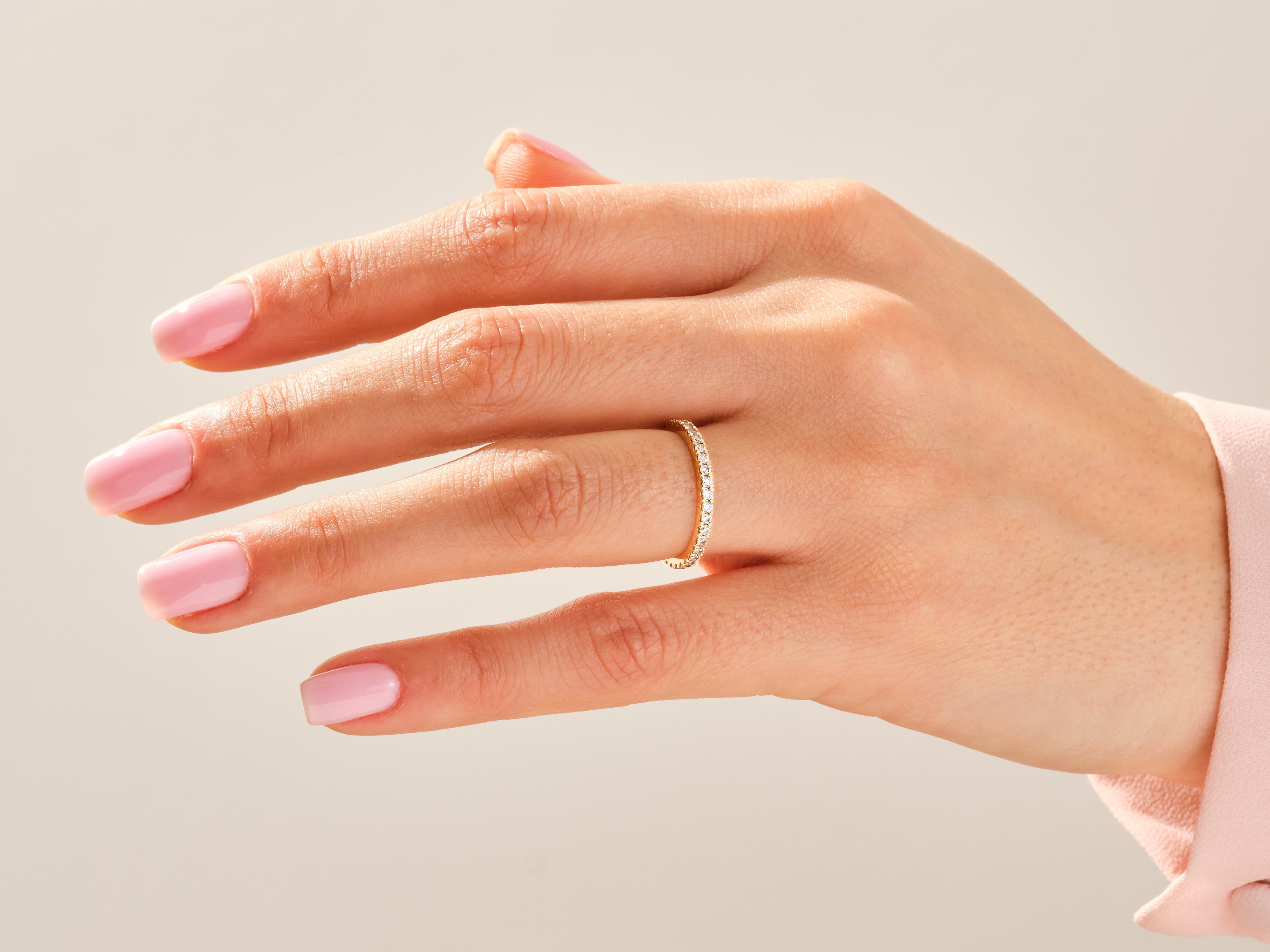 Diamond eternity band on a woman's finger, fine jewelry