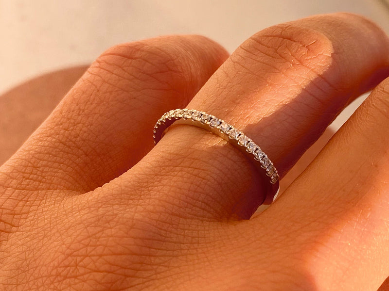 Diamond eternity ring on a finger, fine jewelry for women