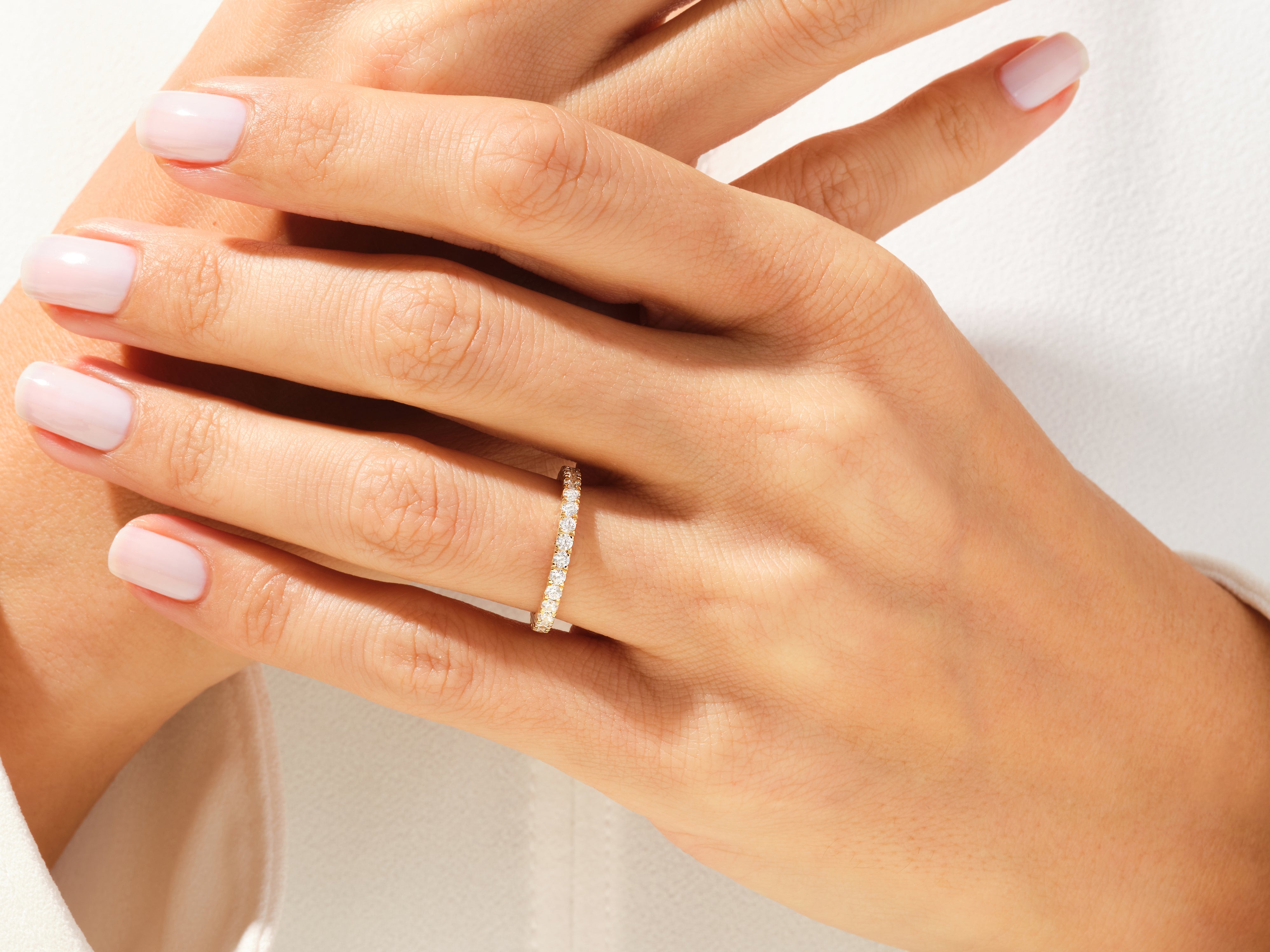 Diamond eternity band on a woman's hand, jewelry firm product