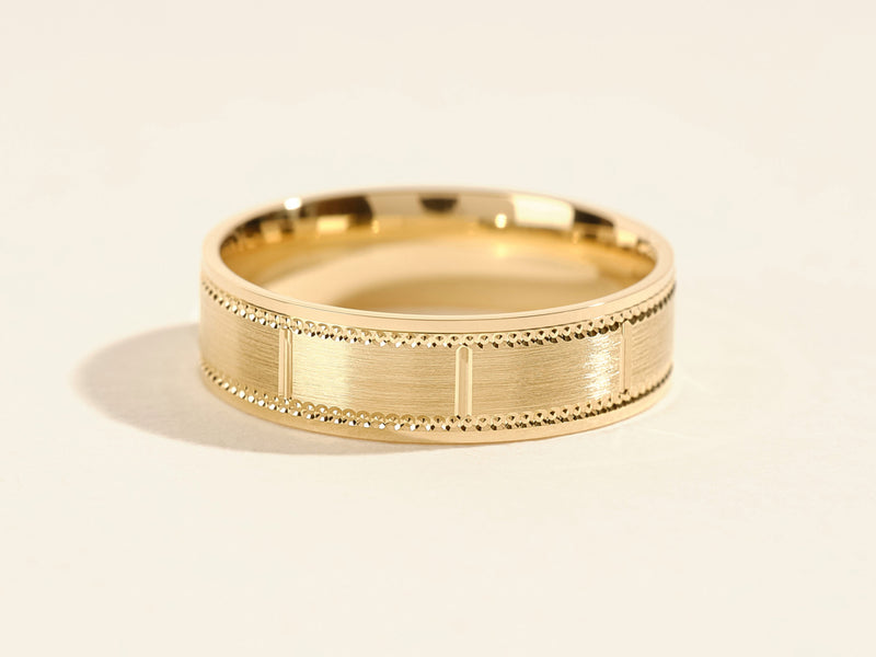 Gold wedding band with textured detail and beaded edges