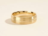 Gold wedding band with brushed finish and polished groove detail