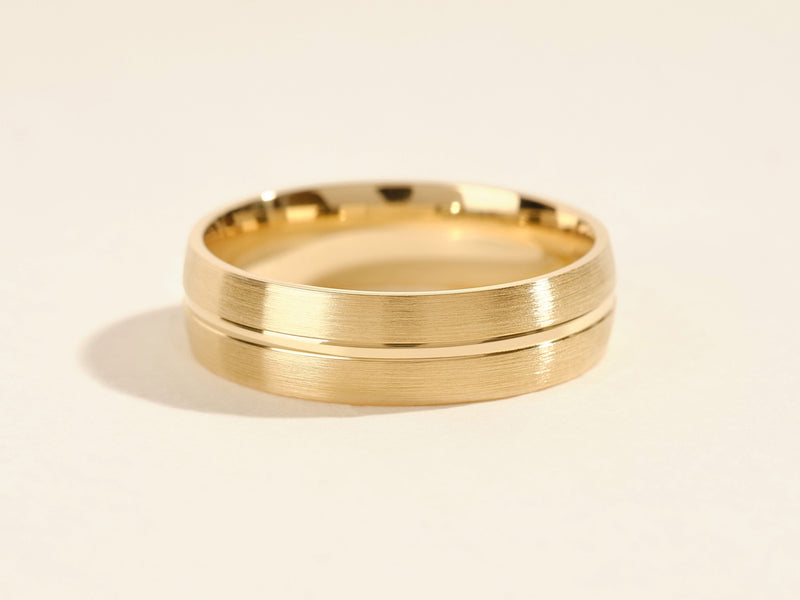 Gold wedding band with brushed finish and polished groove detail