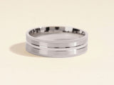 Silver band ring with textured edges and a polished center groove