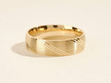 Gold wedding band with brushed finish and diagonal line detail